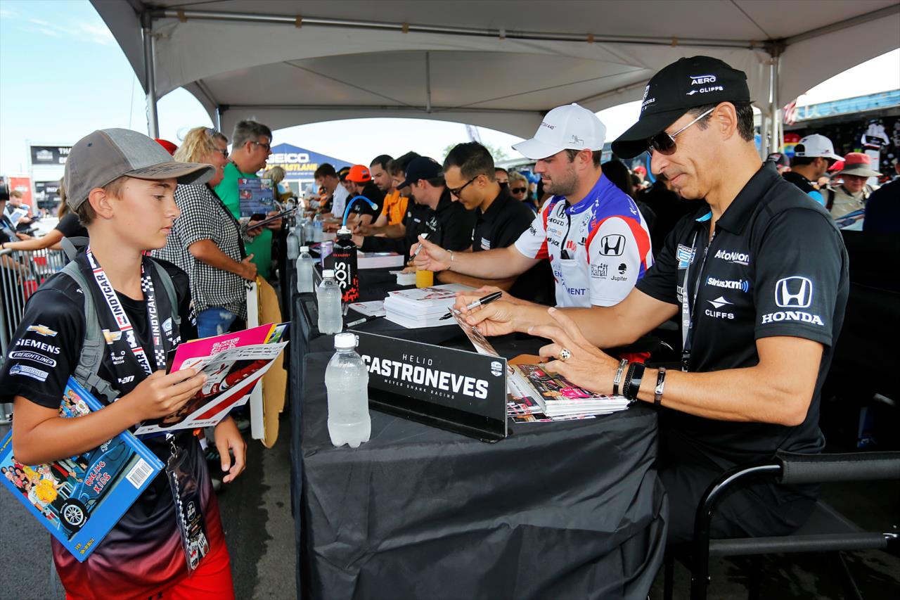 Helio Castroneves signs an autograph for a fan - Gallagher Grand Prix - By: Paul Hurley -- Photo by: Paul Hurley